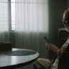 An old man conversating with a talking toad showing him pictures.